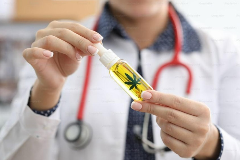 Colombian Dr. cannabis specialist holding bottle of infused oil